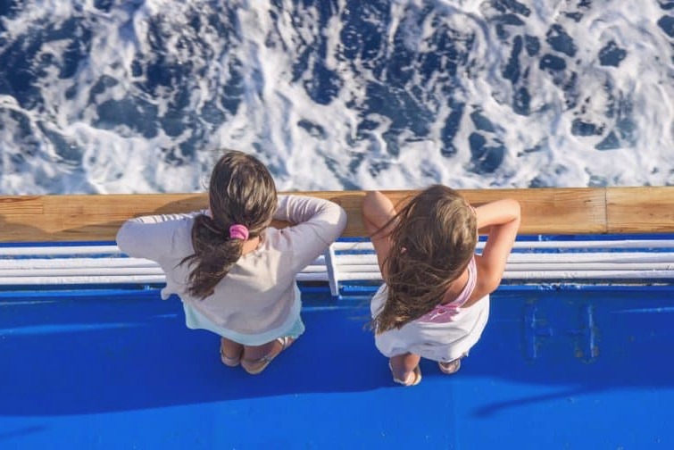 Dos niños en un ferry en el Mar Egeo en Grecia, Naxos Mykonos en barco